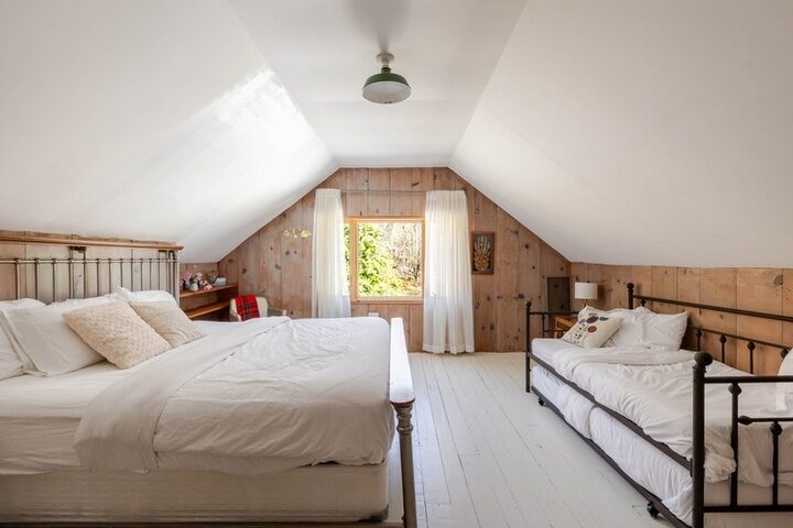 Attic room in the farmhouse at Twelve Ponds with pine walls, painted floors and gabled ceiling.